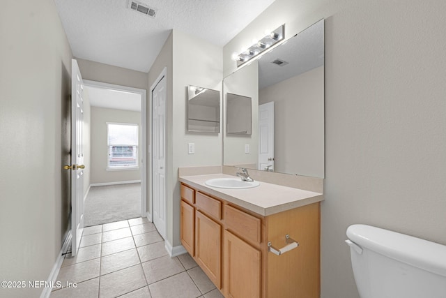 13856 Herons Landing Way Unit 11-7, Jacksonville, FL 32224 - bathroom with toilet, vanity, tile patterned floors, baseboards, and a textured ceiling