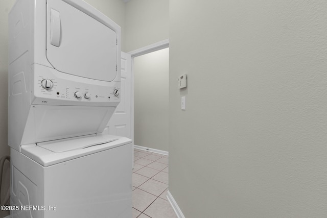 13856 Herons Landing Way Unit 11-7, Jacksonville, FL 32224 - clothes washing area with stacked washer and clothes dryer, light tile patterned flooring, and baseboards