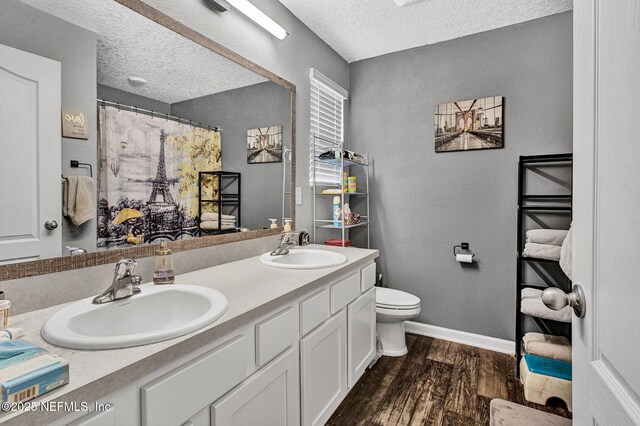 2465 Oak Stream Dr, Green Cove Springs, FL 32043 - full bathroom featuring wood finished floors, a textured ceiling, toilet, a textured wall, and double vanity