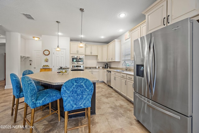 285 Yearling Blvd, Saint Johns, FL 32259 - kitchen with appliances with stainless steel finishes, light countertops, a sink, a breakfast bar area, and a center island