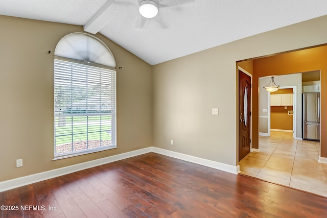 empty room featuring ceiling fan, wood finished floors, baseboards, and a textured ceiling