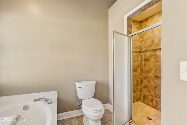 bathroom with a stall shower, a garden tub, toilet, and baseboards