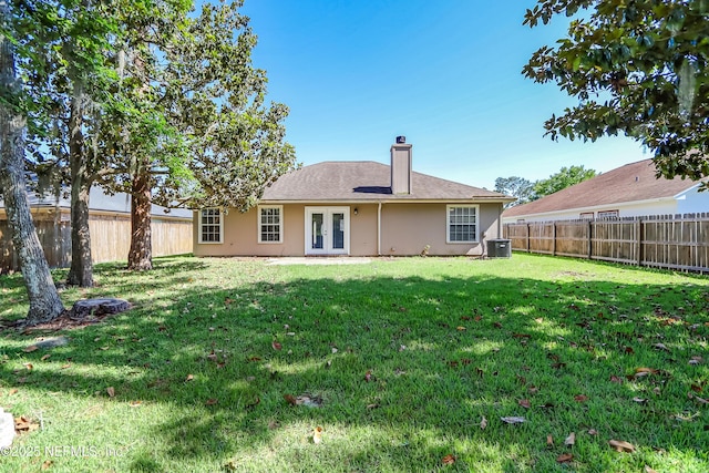 rear view of property with french doors, cooling unit, a chimney, and stucco siding