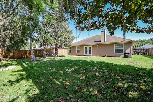 back of property featuring french doors, central air condition unit, stucco siding, and a chimney