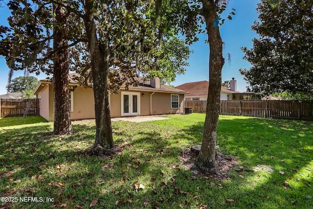 back of property with french doors, stucco siding, and central air condition unit