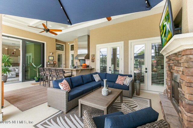 110 Heron Dr, Palm Coast, FL 32137 - living room with track lighting, french doors, ceiling fan, and an outdoor stone fireplace