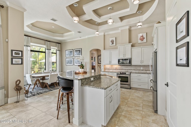 110 Heron Dr, Palm Coast, FL 32137 - kitchen featuring appliances with stainless steel finishes, crown molding, arched walkways, a sink, and a raised ceiling