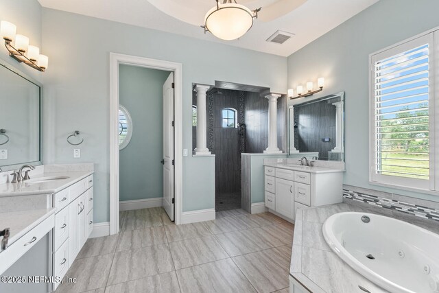 110 Heron Dr, Palm Coast, FL 32137 - bathroom featuring ornate columns, healthy amount of natural light, a whirlpool tub, and two vanities