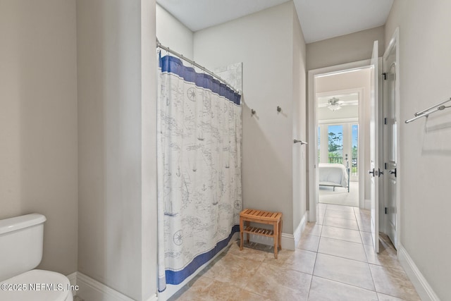 110 Heron Dr, Palm Coast, FL 32137 - bathroom featuring toilet, a ceiling fan, tile patterned flooring, curtained shower, and baseboards
