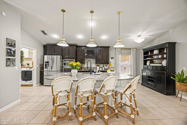 217 Willow Winds Pkwy, Saint Johns, FL 32259 - kitchen featuring stainless steel appliances, lofted ceiling, decorative backsplash, a sink, and a breakfast bar area
