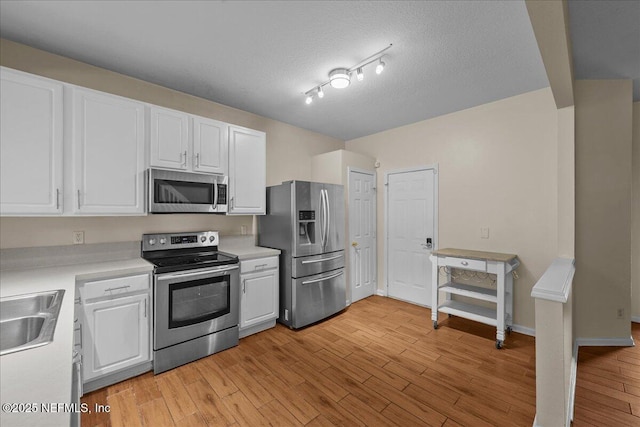 7990 Baymeadows Rd Unit 1305, Jacksonville, FL 32256 - kitchen with stainless steel appliances, white cabinets, light countertops, light wood-style flooring, and a textured ceiling