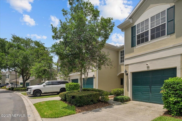 7990 Baymeadows Rd Unit 1305, Jacksonville, FL 32256 - view of side of property featuring concrete driveway, stucco siding, and a garage