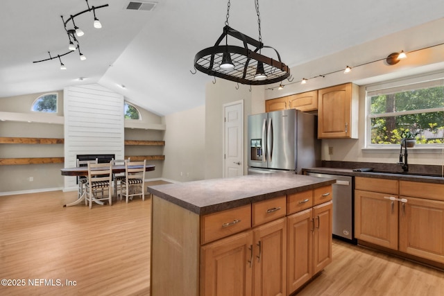 96131 River Marsh Bnd, Fernandina Beach, FL 32034 - kitchen featuring appliances with stainless steel finishes, rail lighting, light wood-type flooring, dark countertops, and vaulted ceiling