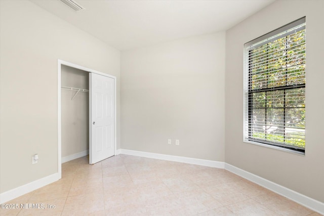 153 Hammocks Landing Dr, Ponte Vedra, FL 32081 - unfurnished bedroom featuring multiple windows, baseboards, light tile patterned floors, and a closet