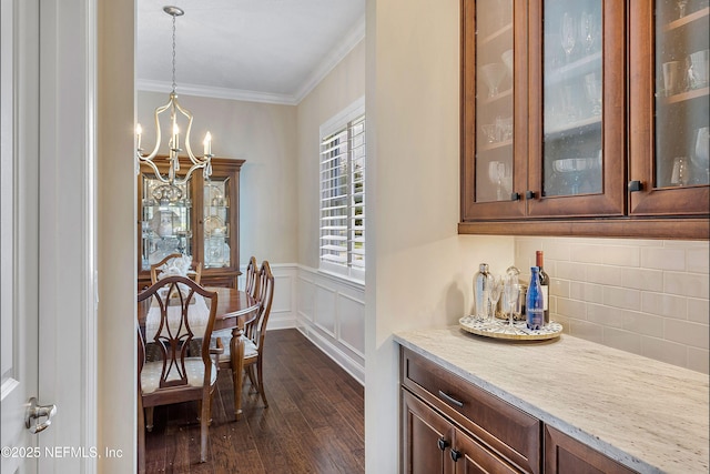 31 Port Ave, Saint Johns, FL 32259 - dining space with dark wood-style floors, a chandelier, ornamental molding, and a wainscoted wall