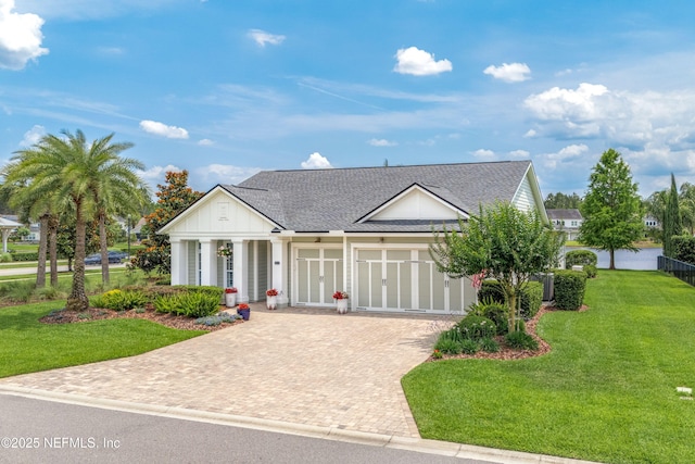 31 Port Ave, Saint Johns, FL 32259 - view of front facade with decorative driveway, a front yard, an attached garage, a shingled roof, and board and batten siding