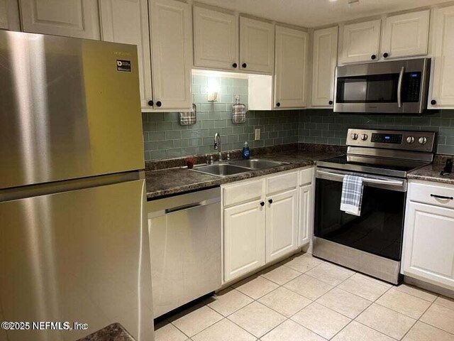 8849 Old Kings Rd S Unit 189, Jacksonville, FL 32257 - kitchen with stainless steel appliances, a sink, dark countertops, white cabinets, and tasteful backsplash