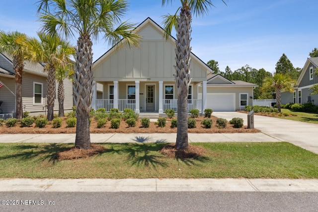 250 Ponder Cir, Yulee, FL 32097 - view of front facade featuring board and batten siding, covered porch, driveway, a garage, and a front lawn