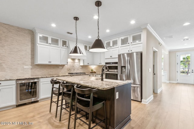 250 Ponder Cir, Yulee, FL 32097 - kitchen featuring beverage cooler, stainless steel appliances, ornamental molding, a center island with sink, and light wood finished floors