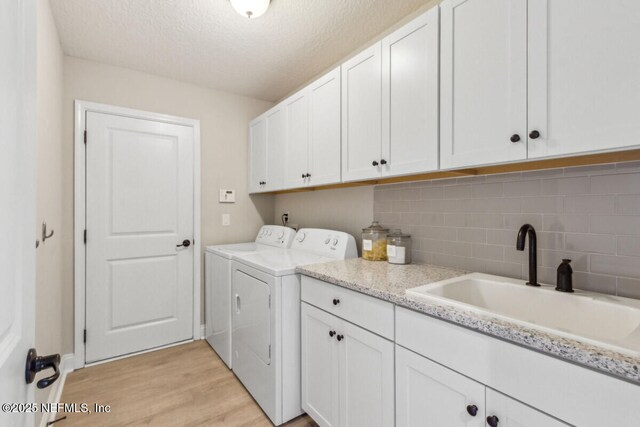 250 Ponder Cir, Yulee, FL 32097 - clothes washing area featuring independent washer and dryer, cabinet space, light wood finished floors, and a textured ceiling