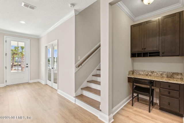 250 Ponder Cir, Yulee, FL 32097 - foyer featuring built in study area, light wood-style floors, stairs, crown molding, and baseboards