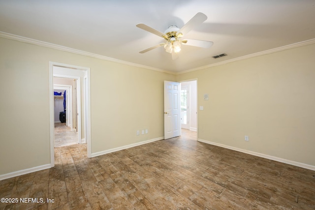 spare room with crown molding, ceiling fan, wood finished floors, and baseboards