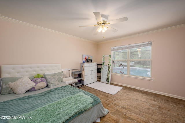 bedroom with crown molding, baseboards, wood finished floors, and a ceiling fan