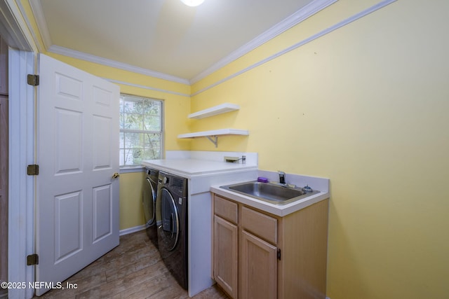 clothes washing area with washer and dryer, ornamental molding, wood finished floors, cabinet space, and baseboards