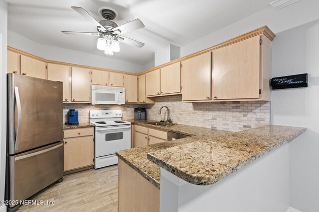 1701 The Greens Way Unit 1411, Jacksonville Beach, FL 32250 - kitchen featuring stainless steel appliances, a sink, a peninsula, and light brown cabinetry