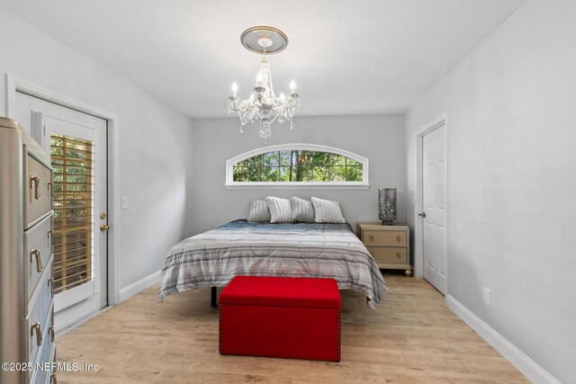 1701 The Greens Way Unit 1411, Jacksonville Beach, FL 32250 - bedroom featuring a chandelier, multiple windows, wood finished floors, and baseboards