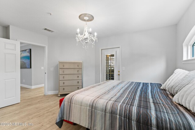 1701 The Greens Way Unit 1411, Jacksonville Beach, FL 32250 - bedroom featuring a chandelier, light wood-style floors, and baseboards