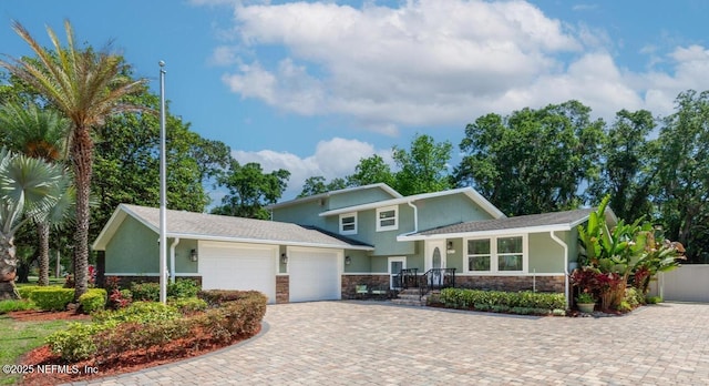 1823 Mauva Juan Ave, Jacksonville, FL 32225 - split level home with stone siding, an attached garage, driveway, and stucco siding