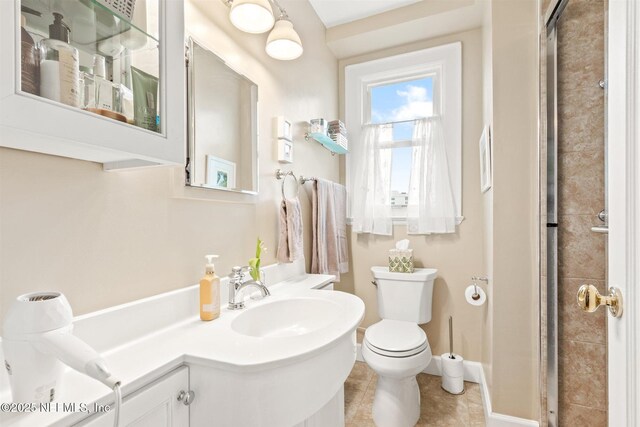 1846 Margaret St Unit 7C, Jacksonville, FL 32204 - bathroom featuring a sink, toilet, tile patterned floors, an enclosed shower, and baseboards