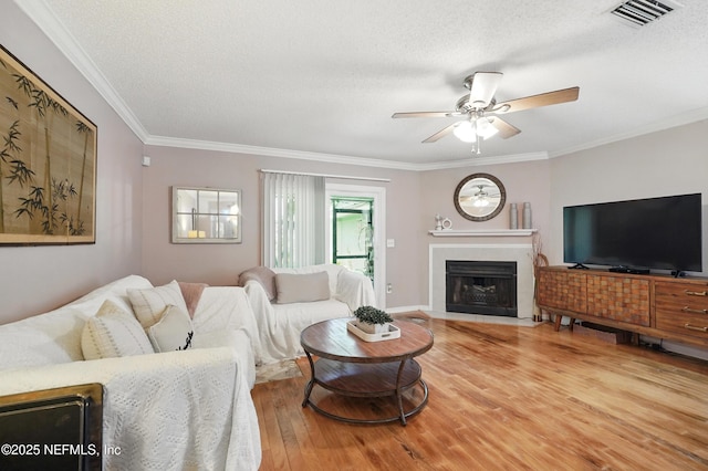 705 Marsh Cove Pl, Ponte Vedra Beach, FL 32082 - living area with ornamental molding, a ceiling fan, wood finished floors, a fireplace with flush hearth, and a textured ceiling