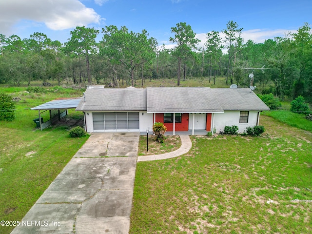 23063 SW Edgewater Blvd, Dunnellon, FL 34431 - view of front of home featuring an attached garage, driveway, a front lawn, and stucco siding