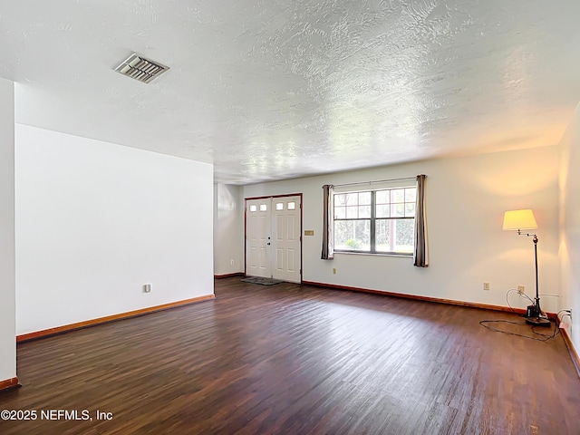 23063 SW Edgewater Blvd, Dunnellon, FL 34431 - unfurnished living room with dark wood-style floors, baseboards, and a textured ceiling