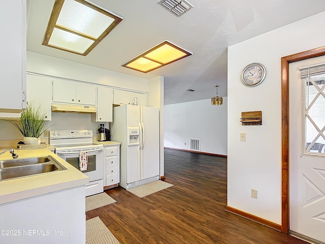 23063 SW Edgewater Blvd, Dunnellon, FL 34431 - kitchen with white appliances, under cabinet range hood, light countertops, dark wood-type flooring, and baseboards