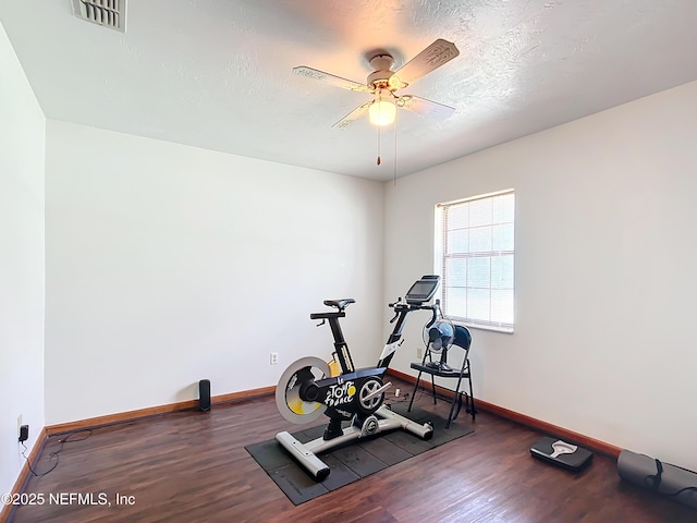 23063 SW Edgewater Blvd, Dunnellon, FL 34431 - workout area featuring wood finished floors, baseboards, a ceiling fan, and a textured ceiling
