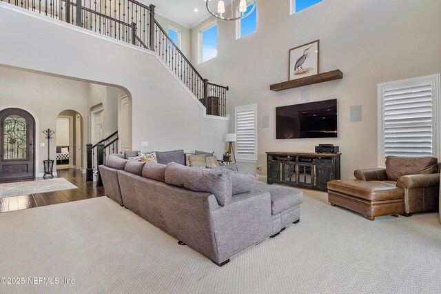 361 Amalurra Trl, Saint Johns, FL 32259 - living area with arched walkways, a high ceiling, stairs, wood finished floors, and baseboards