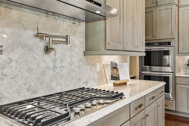 361 Amalurra Trl, Saint Johns, FL 32259 - kitchen featuring appliances with stainless steel finishes, tasteful backsplash, dark wood-type flooring, light stone counters, and extractor fan