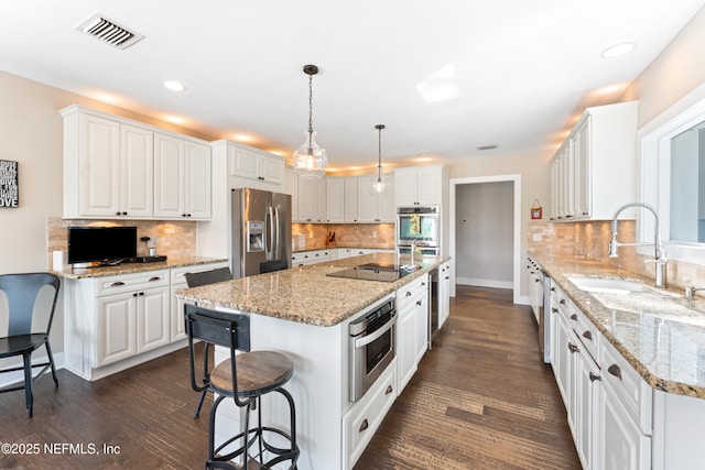 24544 Deer Trace Dr, Ponte Vedra Beach, FL 32082 - kitchen with stainless steel appliances, a sink, a kitchen breakfast bar, white cabinetry, and recessed lighting