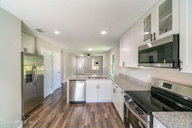 409 Willow Branch Ave, Jacksonville, FL 32254 - kitchen featuring appliances with stainless steel finishes, a peninsula, dark wood-type flooring, white cabinets, and recessed lighting