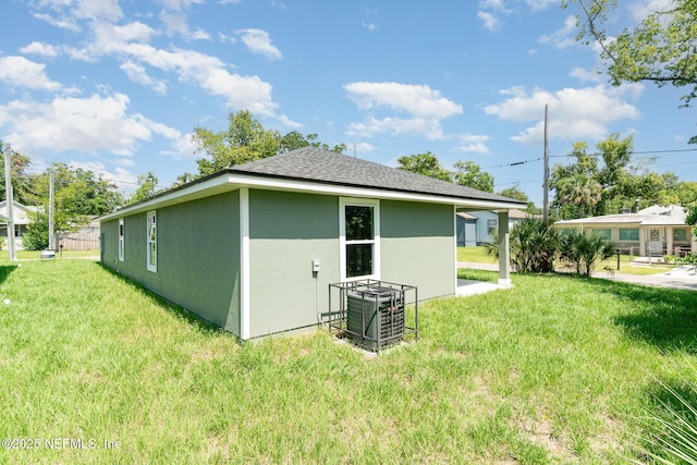 409 Willow Branch Ave, Jacksonville, FL 32254 - back of house featuring a yard, stucco siding, and roof with shingles
