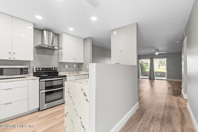 7142 Cypress Cove Rd Unit 39, Jacksonville, FL 32244 - kitchen featuring appliances with stainless steel finishes, wall chimney exhaust hood, light wood finished floors, baseboards, and white cabinetry