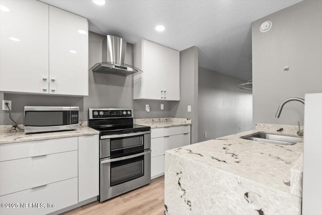 7142 Cypress Cove Rd Unit 39, Jacksonville, FL 32244 - kitchen with stainless steel appliances, wall chimney exhaust hood, a sink, light wood-type flooring, and light stone counters
