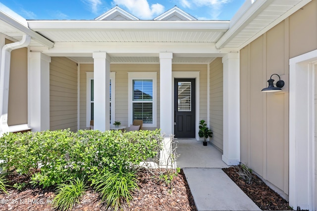 property entrance with board and batten siding and covered porch