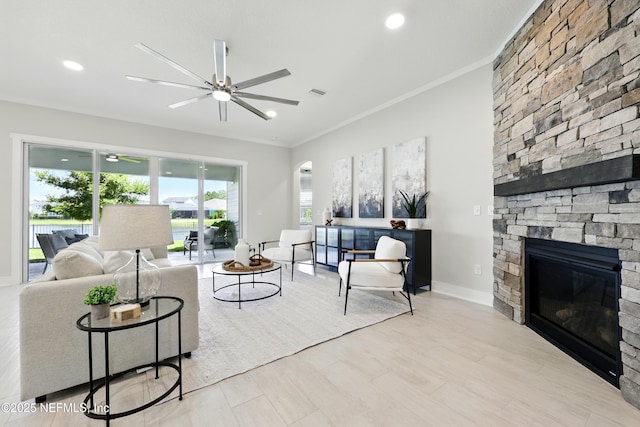 living area featuring ceiling fan, ornamental molding, a fireplace, recessed lighting, and wood finished floors