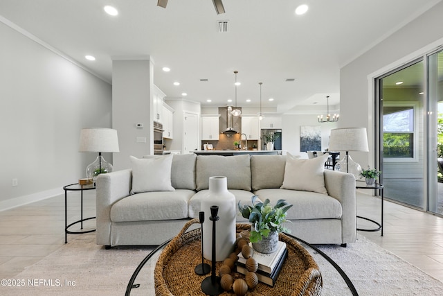 living area featuring ornamental molding, recessed lighting, a chandelier, and a ceiling fan