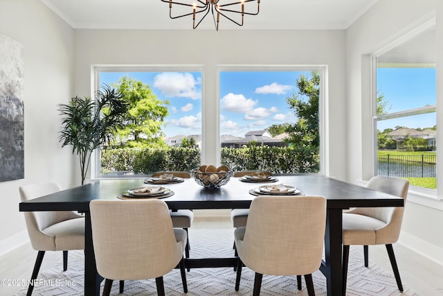 dining area with baseboards, a chandelier, plenty of natural light, and crown molding