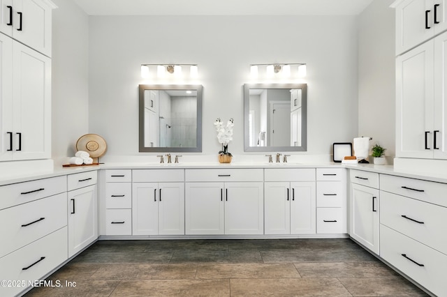 full bathroom with tiled shower and double vanity